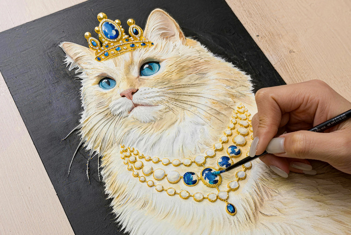 Artist adding blue color to jewelry details on a hand-sculpted white cat relief portrait